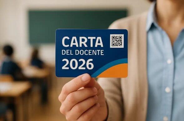 Persona che mostra la bonus Carta l Docenti 2026 in un’aula scolastica, con studenti seduti ai banchi sullo sfondo.