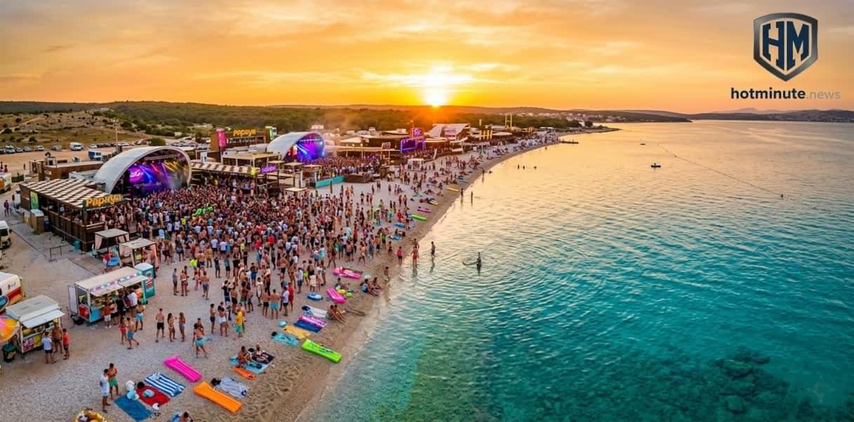 Zrće Beach 2026 spiaggia di zrce affollata al tramonto con musica dal vivo palchi illuminati e ragazzi che ballano vicino al mare